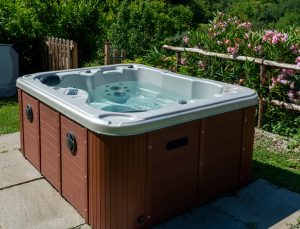 Outdoor hot tub filled with steaming water, illustrating residential hot tub ownership and the electricity required to heat and maintain water temperature year-round.